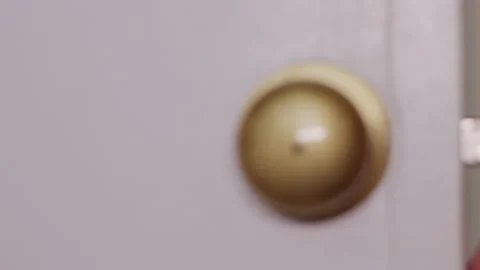 Close-up of a person opening a white interior door by turning the brass knob Stock Footage 342390635