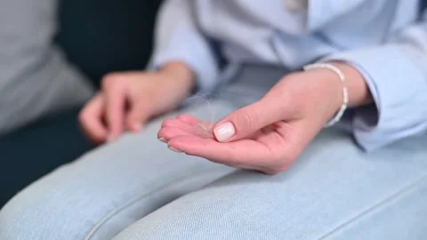 Close-up of a person picking wool from his pants and showing a pile of animal Stockbeeldmateriaal 337101068
