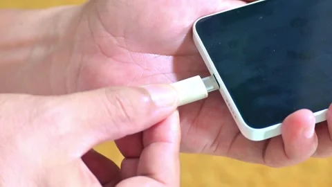 Close up of person plugging a damaged frayed cable into a smartphone Stock Footage 328932554