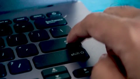 Close up of a person pressing the enter key repeatedly on a computer laptop.. Stock Footage 340489644