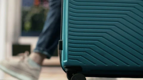 Close up of person pulling trolley baggage across bus station platform Stock Footage 340201841