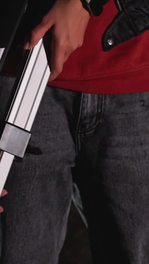 Close up of person in red top adjusting white metal ladder components with hands Vidéo 343076750