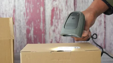 Close up of person scanning a barcode on cardboard box with a barcode scanner Stock Footage 332578169