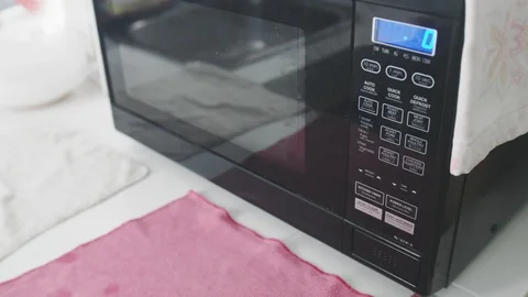 Close up of a person setting timer on a microwave then start it. Stock Footage 107914005