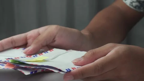 Close up of person sorting envelopes on table with curtain background Stock Footage 276636952