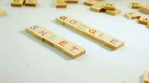 Close up of a person spelling Google Sheets with wooden letters on an off Stock Footage 104912120