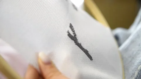 Close up of person stitching black thread on white fabric with wooden embro.. Stock Footage 334955057