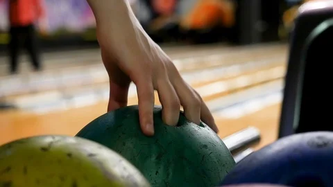 Close up for a person taking a ball on bowling alleys background, bowling group Stock Footage 116076667