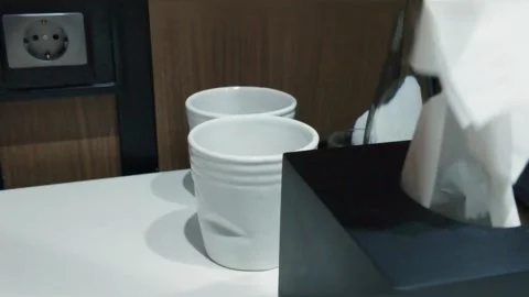 Close-up of a person taking a paper tissue from a black napkin dispenser. 動画素材 344094045