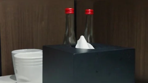 Close-up of a person taking a paper tissue from black square tissue box dispense 動画素材 344094253