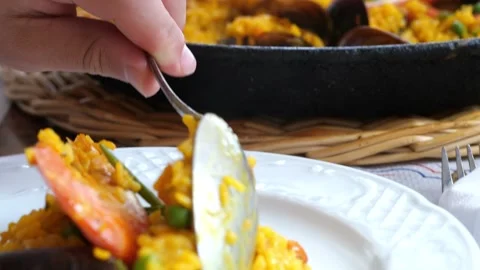 Close-up of a person taking a spoon full of traditional Spanish seafood pae.. Video stock 344031588