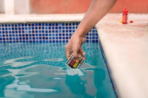 Close up of person testing the ph of the water with mini tester in swimming.. Stock Photos