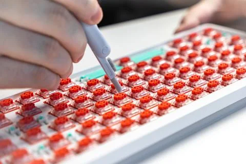 Close-up of person testing red mechanical switches on keyboard with probe d.. Stock Photos