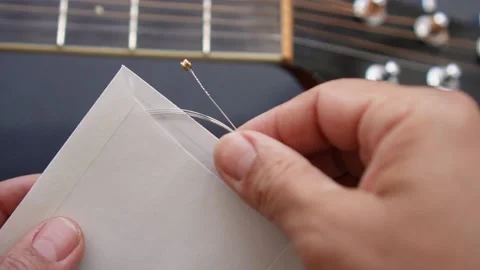 Close-up of person tuning and changing guitar strings Stock Footage 196348410