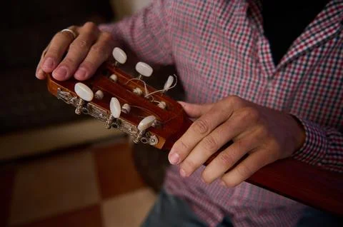 Close-up of a person tuning the strings of a classical guitar Stock Photos