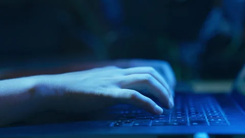 Close-Up of Person Typing on Laptop Keyboard in Blue Lighting Stock Footage 340240331