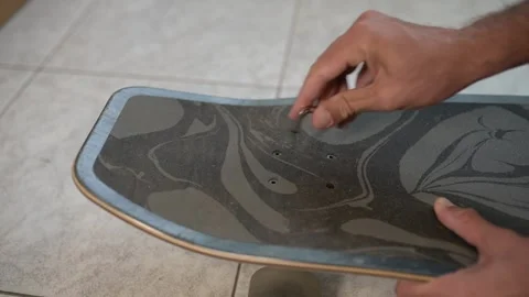 Close-up of a person using an Allen key to assemble or adjust a surfskate Stock Footage 318594367