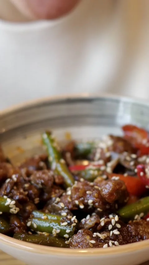 Close up of a person using chopsticks to eat delicious asian teriyaki beef with Stock Footage 345406397