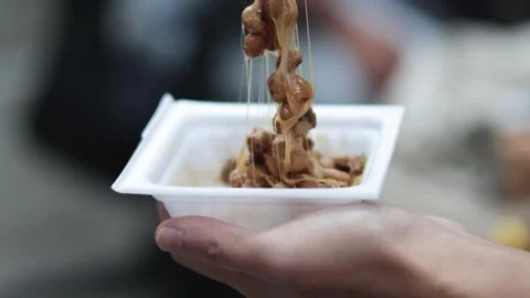 Close up of person using chopsticks to pull sticky fermented natto soybeans.. Stock Footage 333937052