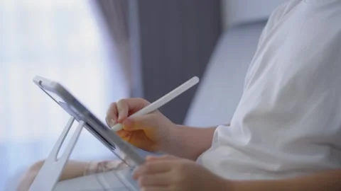 Close-up of a person using a digital tablet with a stylus in an indoor sett.. Stock Footage 337527296