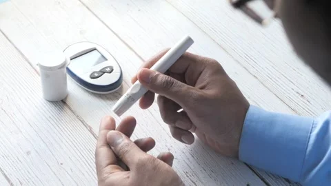 Close up of person using lancet device to test blood glucose levels. Vídeos de archivo 332776782