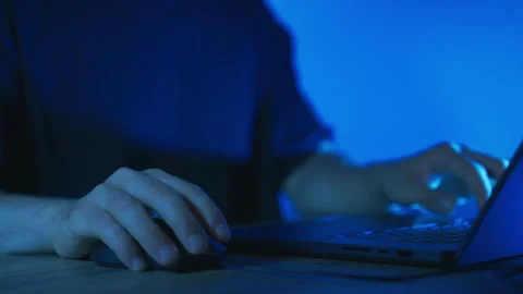 Close-Up of Person Using Laptop and Mouse in Blue Light Stock Footage 340290400