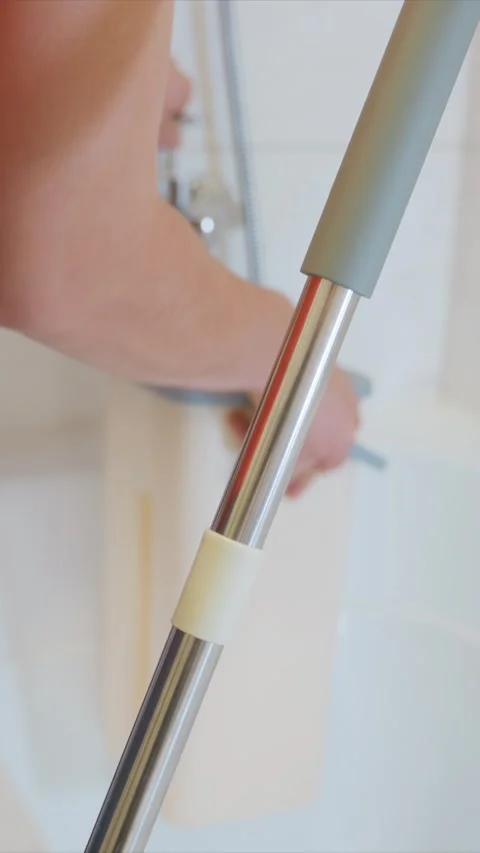 Close up of person using metallic handled cleaner in bathroom with cleaning tool Vídeo Stock 346787087