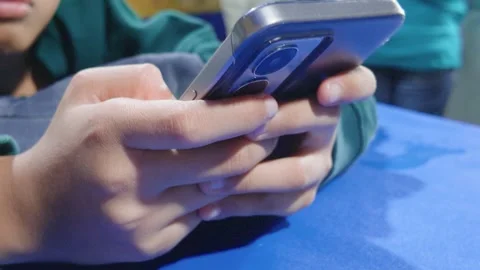 Close up of person using modern smartphone with blue background. 库存影片 343382480