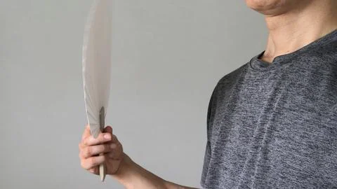 A close-up of a person using a round fan. Stock Photos