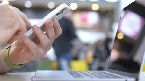 Close-up of person using smartphone beside open laptop Stock Footage 341184606