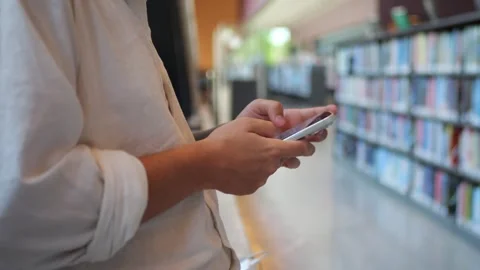 Close-Up of Person Using Smartphone in Library, Mobile Communication... Stock-Footage 334437094