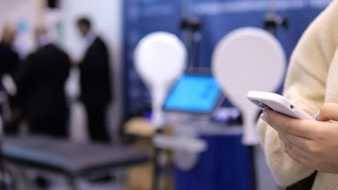 Close-up of person using smartphone at tech expo Stock Footage 348588934
