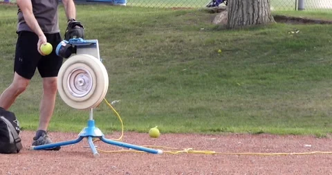 Close up to a person using a Softball Pitching Machine with high speed range Stock Footage 245410389