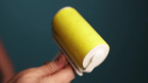 Close-up of a person using a sticky lint roller for cleaning clothes Stock Footage 340265726