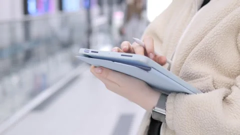 Close-up of person using tablet in busy indoor space Stock Footage 348228814