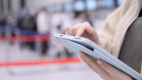 Close-up of person using tablet while seated at airport Stock Footage 339492822