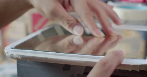 A close-up of a person using their finger to spread and smooth silicone glue. Stock Footage 312311911