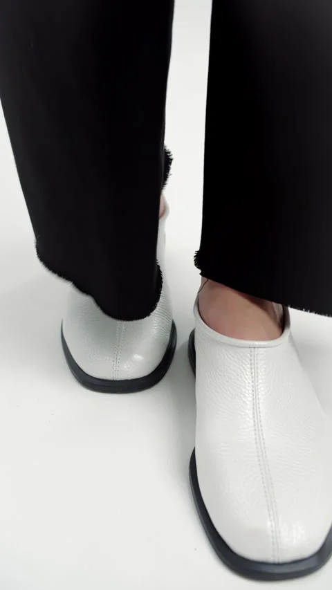 Close-up of person walking forward in white slip-on shoes Video stock 321314248