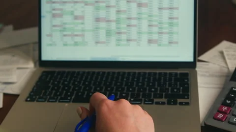 Close-up of a person working on financial data on a laptop with spreadsheet Stock Footage 335277708
