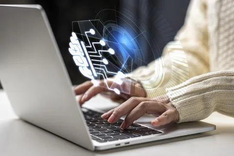 Close up of a person working on a laptop, featuring a glowing holographic n.. Stock Photos
