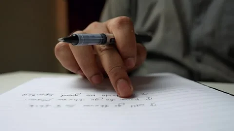 Close-up of a person writing on a lined notebook with a pen Stock Footage 318578222