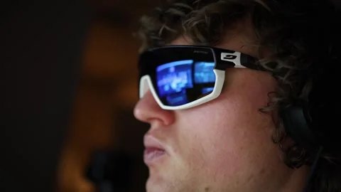 A close-up of a person's face reflects a computer screen displaying video editin Stock Footage 297112953