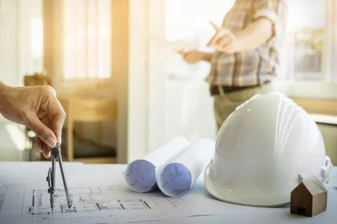 Close-up Of Person's Hand Drawing Plan On Blue Print with architect equipment Fotos de archivo