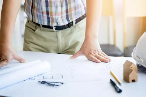 Close-up Of Person's Hand Drawing Plan On Blue Print with architect equipment Fotos de archivo