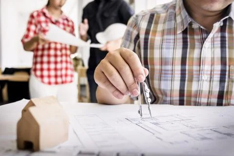 Close-up Of Person's Hand Drawing Plan On Blue Print with architect equipment Fotos de archivo