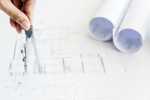 Close-up Of Person's Hand Drawing Plan On Blue Print with architect equipment Fotos de archivo