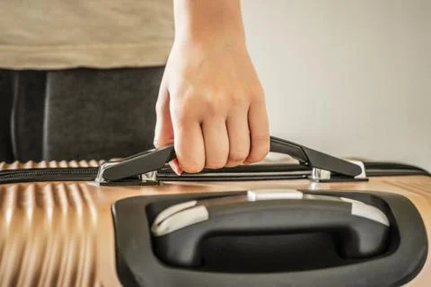 Close-up of a person's hand holding a suitcase handle Stock Photos