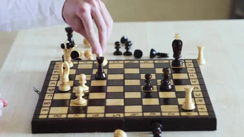 Close-up of a person's hand moving a chess piece on a wooden board Stock Footage 278900381