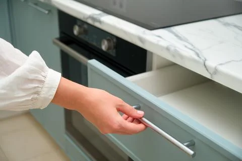 Close Up of a Persons Hand Opening a Light Blue Kitchen Drawer with a Marble  Stock Photos