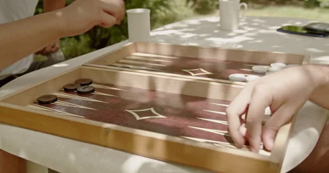 Close-up of a persons hand playing backgammon on a sunny day, capturing the laid Stock Footage 281575926